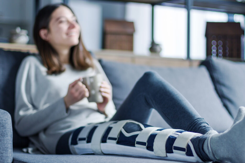 Woman sits with leg in a cast awaiting settlement