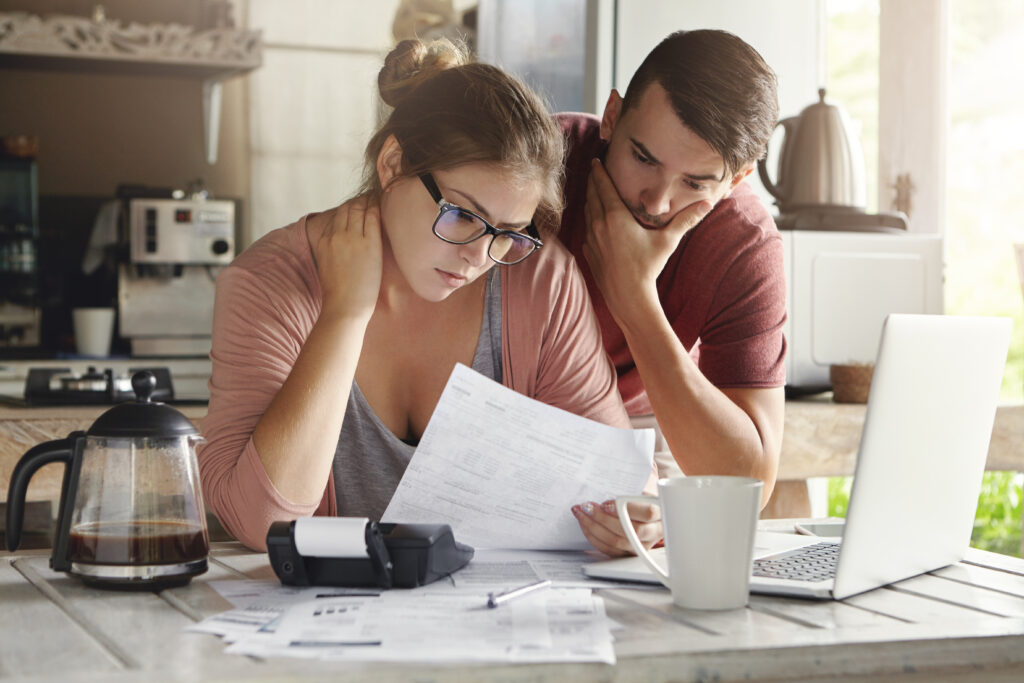 Couple sits around kitchen table paying medical bills