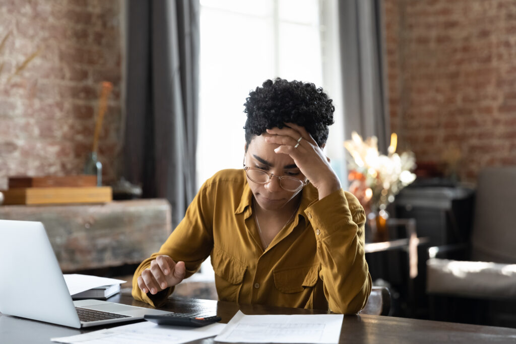 Woman looks concerned, struggles to pay bills
