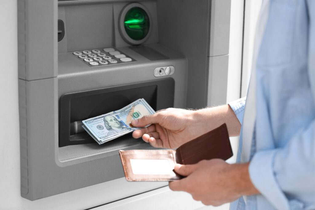 Person takes money out of an ATM after getting another pre-settlement loan for their case