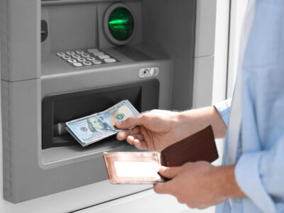 Person takes money out of an ATM after getting another pre-settlement loan for their case